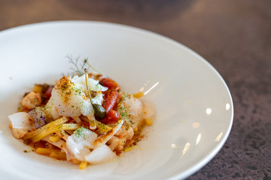 Scialatiello con pescatrice e calamari, “Pomodorino del Piennolo del Vesuvio D.O.P.”, polvere di olive nere e fiore in cappero